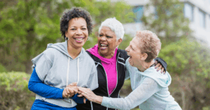 Three older women smiling outside