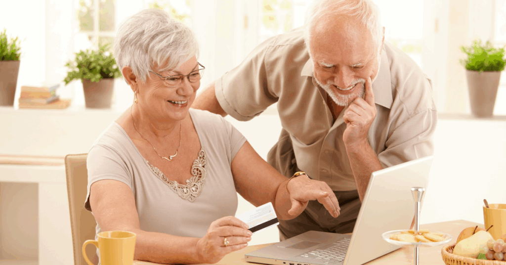 Two older adults looking at a laptop