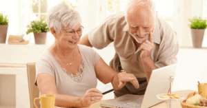 Two older adults looking at a laptop
